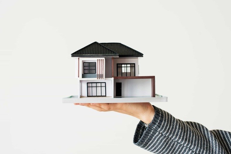 image d'une maison miniature posé dans une main illutrant la section qu'est qu'un audit energetique